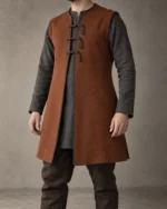 Godric Sleeveless Norse-Inspired Coat in rust brown over a dark long-sleeve tunic