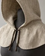 Close-up of the Rowan Linen Peasant Hood showing the face edge and braided throat ties