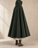 Rear view of the Thornmere Wool Traveler Cloak showing its hood and broad hem sweep