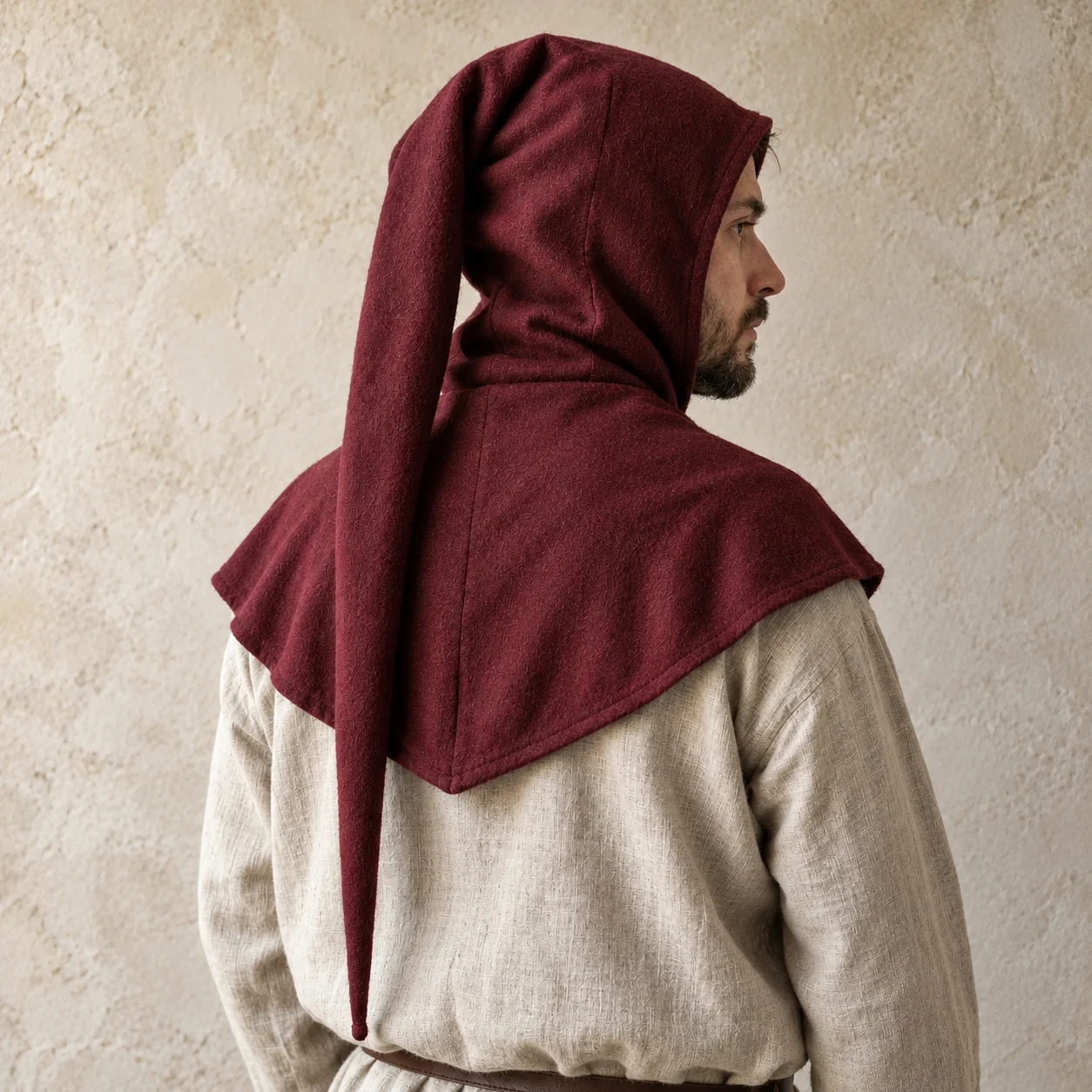 Rear three-quarter view of a burgundy wool liripipe hood with a long tapered tail