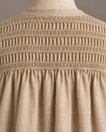 Natural beige smocked-yoke button robe, close-up of the gathered back yoke and smocking